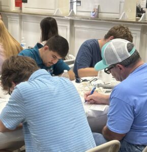 A group of young men are currently filling out applications to volunteer for an organization or cause.