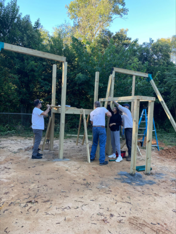 Group of people help to assemble the play house structure.