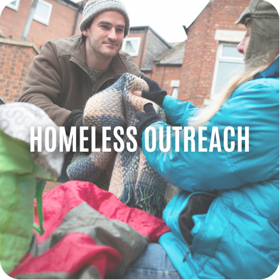 Two people outdoors exchanging blankets with text “HOMELESS OUTREACH” overlaid on the image.