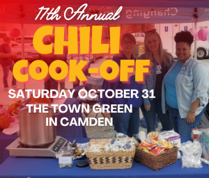 Three women stand behind a table of chili and snacks at the 11th Annual Chili Cook-Off in Camden.