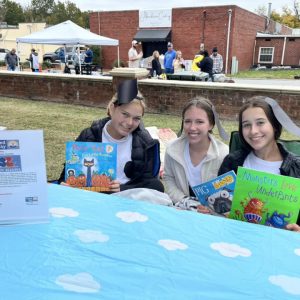 Imagine a chili cookoff where three girls are dressed up as puppy dogs. They are all holding children's books to sponsor a program called Ready Readers.